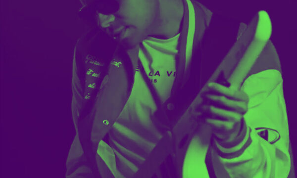 A duotone photo of Angelo Keys - a member of Bandancha - playing a keytar.