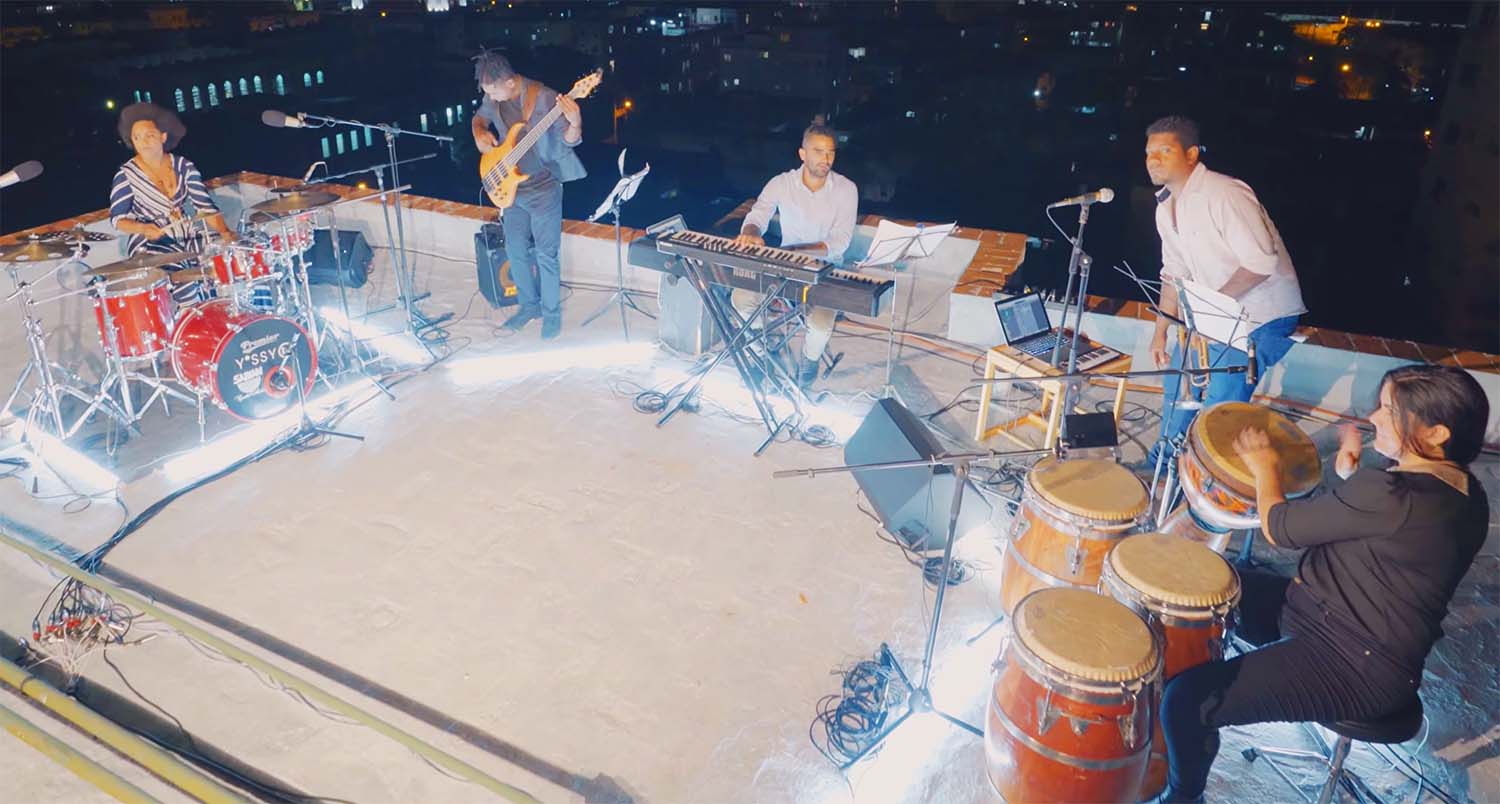 Aerial view of Yissy Garcia and Bandancha performing En un despertar on a rooftop
